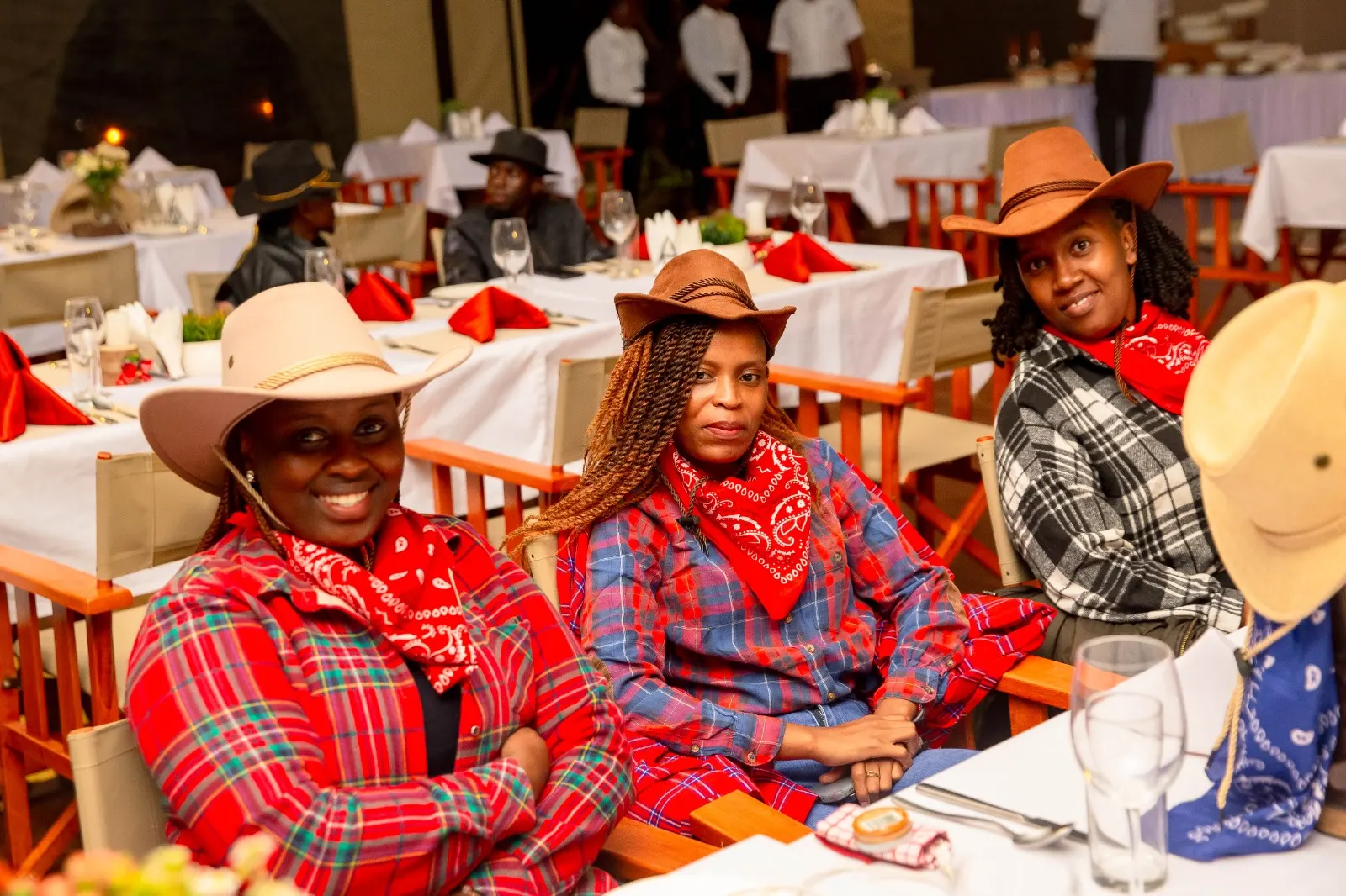 Friends in western dress seated at a candlelit themed dinner night at Mtalii Bush Camps