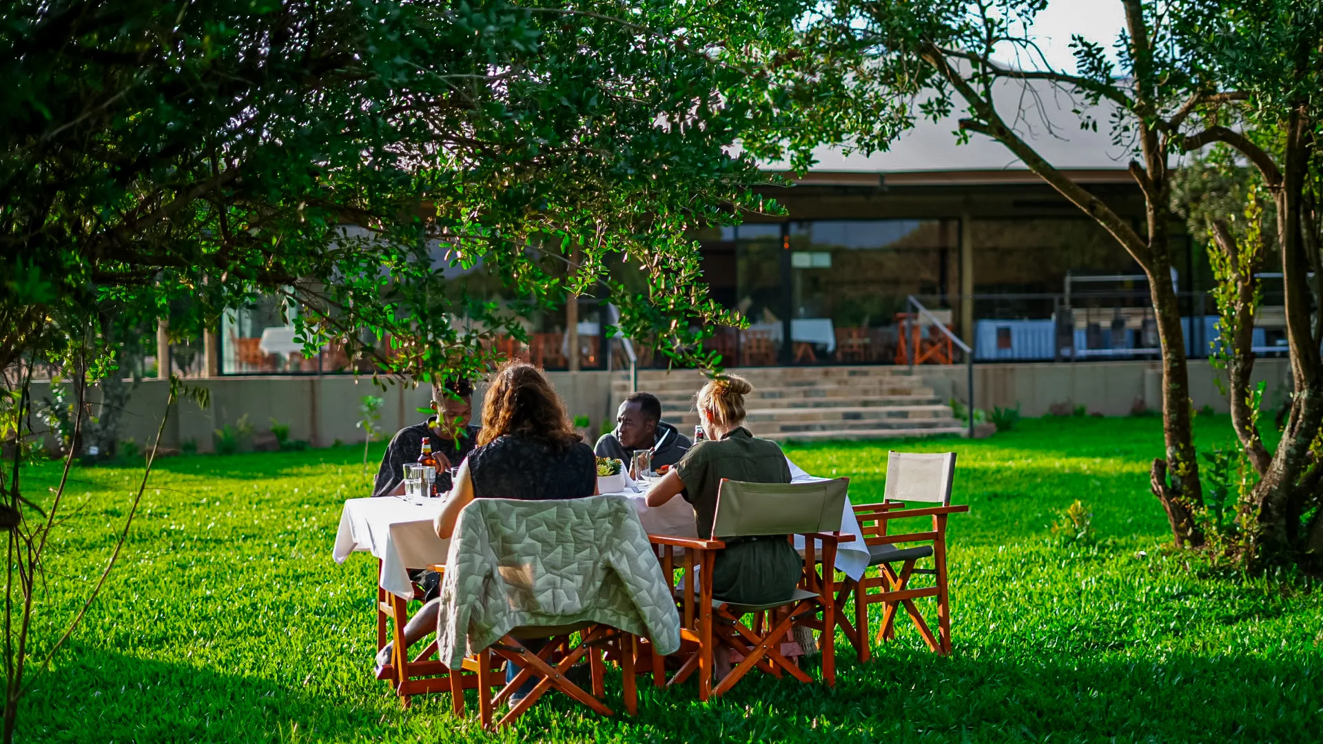 Outdoor dining under a canopy of trees at Mtalii