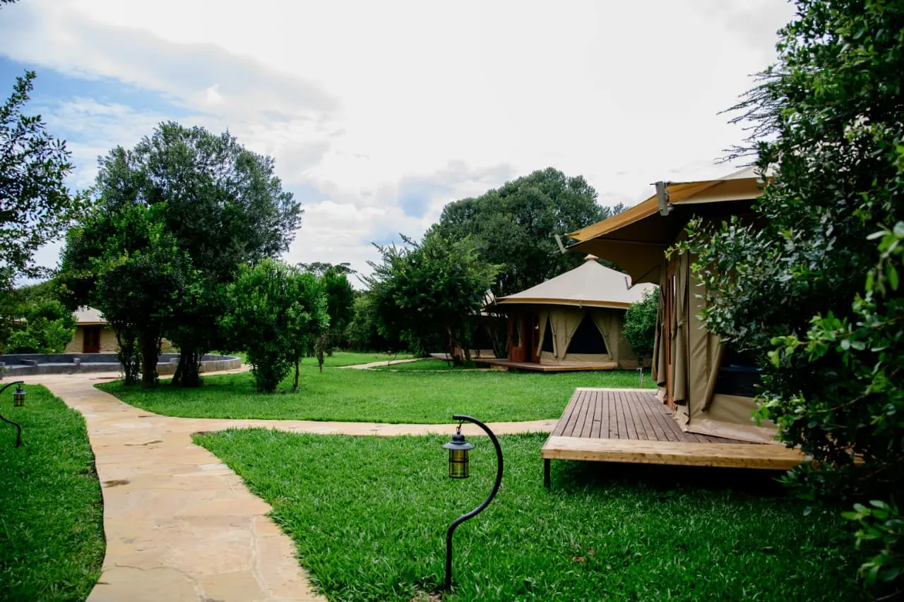 Tented suites with timber decks set along a flagstone path through the village garden